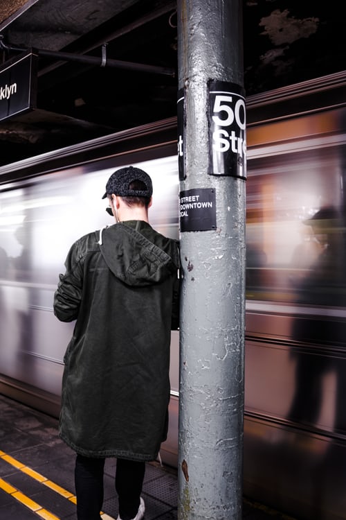 guy standing next to subway train